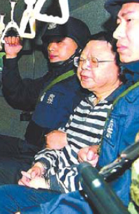 Wen Qiang is escorted by police in a file photo.