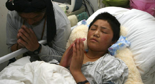 Xi’an: A transferred Yushu patient mourns for the Yushu victims in the First Affiliated Hospital of the Medical College of Xi’an Jiaotong University on April 21, 2010. 