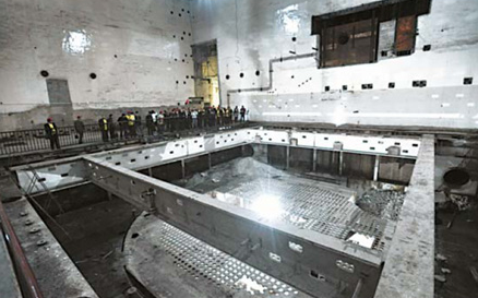 Visitors wonder around one of the huge nuclear reaction 'cauldrons' in the center of a nuclear reactor hall inside the Baitao cave. 