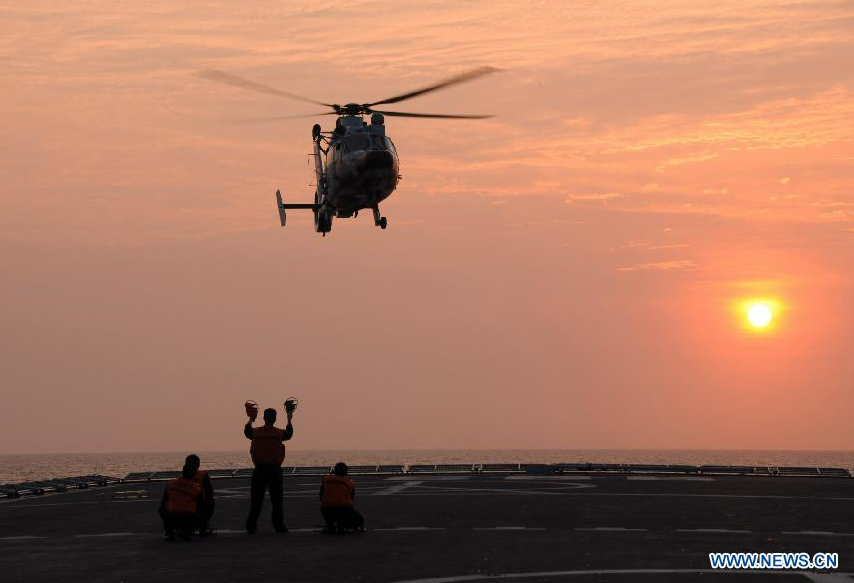  A Z-9 helicopter prepares to land on the warship Jinggangshan in waters near south China's Hainan Province, March 20, 2013.[Photo/Xinhua]