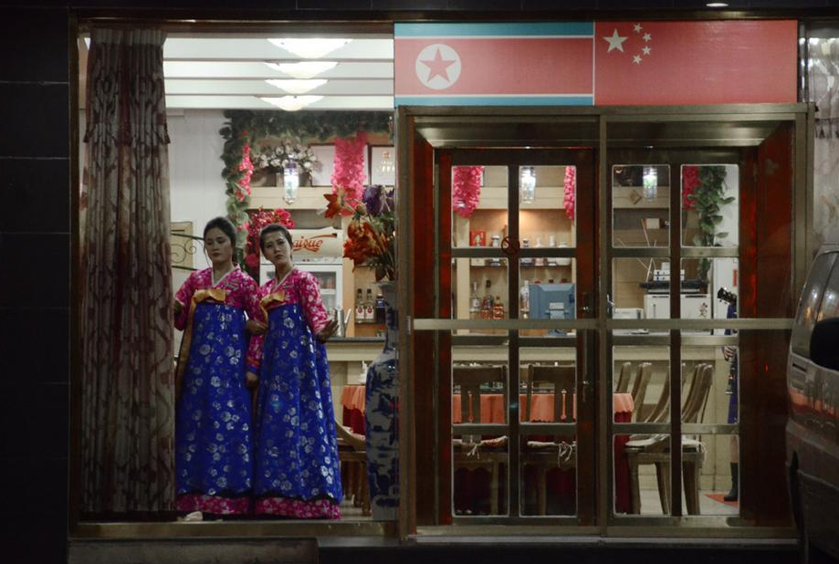 Two North Korean waitresses welcome people at the gate of the a restaurant as ushers in Dandong, Liaoning Province, on Dec. 12, 2012.