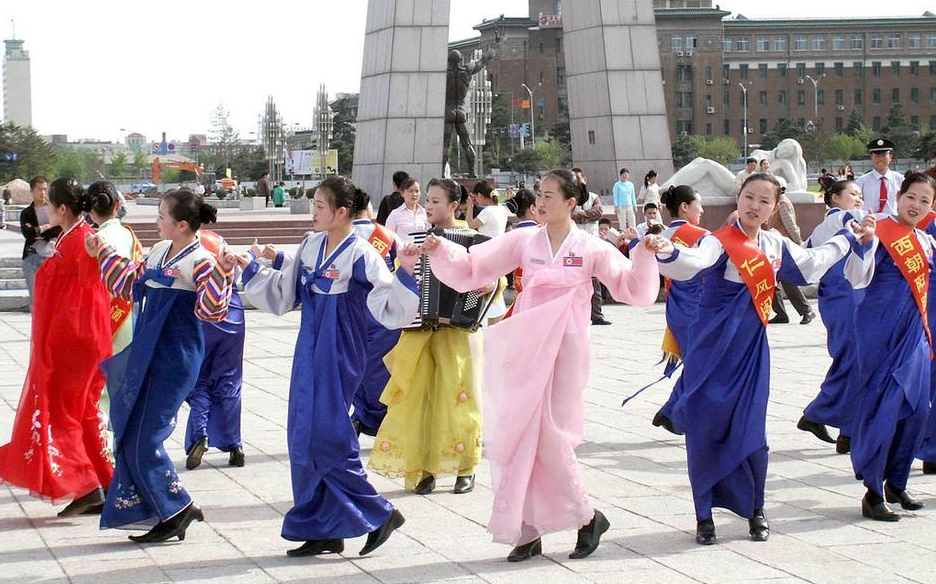 North Korean waitresses perform traditional folk dances in a square in Changchun City, on May 11, 2004.