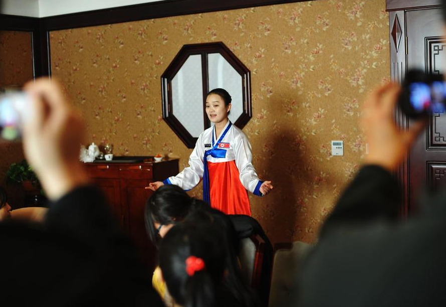 A North Korean waitress serves customers and performs at a restaurant with special North Korean flavor in Changchun City, Jilin Province, on Dec. 5, 2012.[Photo/Sina]