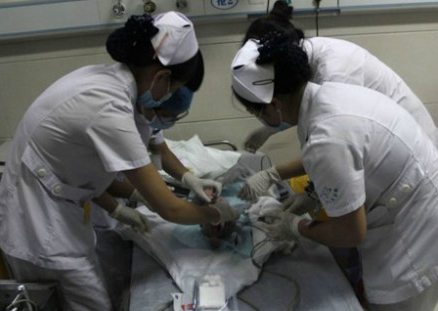 Firefighters and doctors rescue a newborn baby by cutting away a sewage pipe piece by piece, in this still image taken from video, in Jinhua city, Zhejiang province May 25, 2013. [Photo/Weibo.com] 