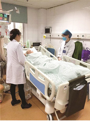 Doctors stand beside Yan Baozhen at Nanjing Hospital of T.C.M. in Nanjing, capital city of East China’s Jiangsu province. on Nov 18, 2015. [Photo/xhby.net]
