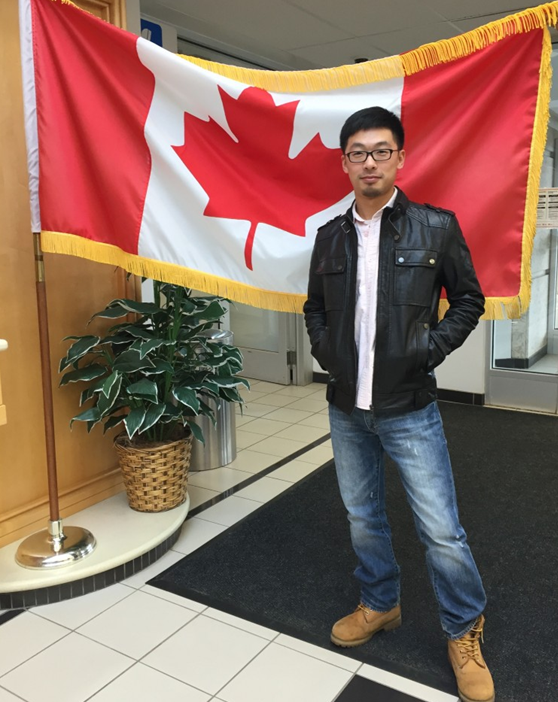 Hu Juyuan takes a picture with the Canadian national flag. [China.org.cn] 