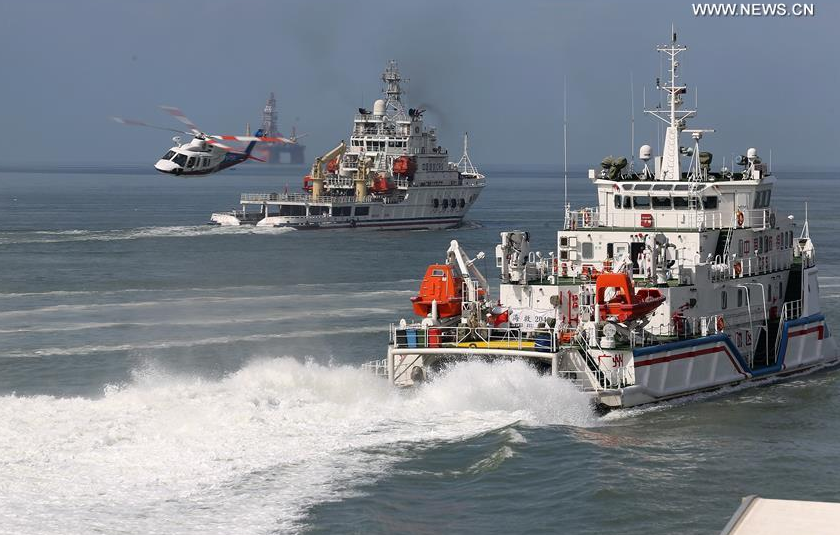 Rescue vessels and a helicopter take part in an emergency rescue drill held at the sea area near the Fenghuang Island in Sanya, south China's Hainan Province, Aug. 23, 2016. The drill aimed at enhancing emergency response skills of maritime rescue teams. [Photo: Xinhua]