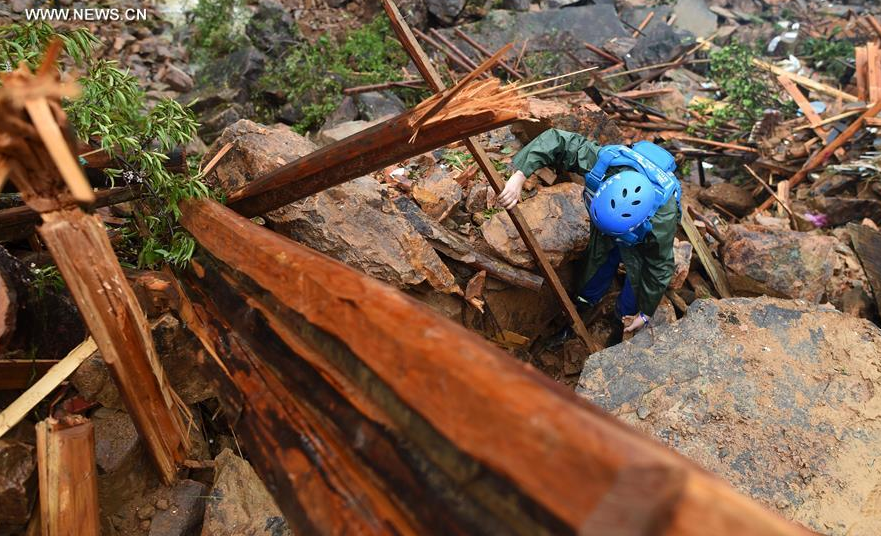 A member of Blue Sky Rescue team searches for missing people at the accident site after a landslide hit Suichang County, east China's Zhejiang Province, Sept. 29, 2016.[Photo/Xinhua]