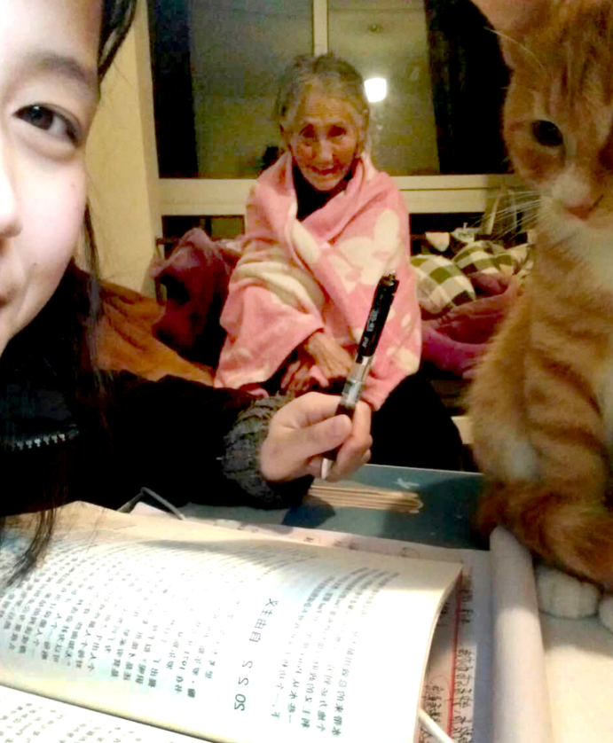 Liu Lin taks a photo with her gramdma and their pet cat at their rented home. (Photo: VCG)