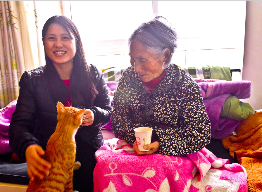 Liu Lin taks a photo with her gramdma and their pet cat at their rented home. (Photo: VCG)