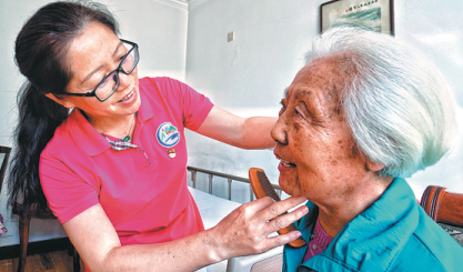 A nurse at Sijiqing Nursing Home combs the hair of an elder resident at the Beijing facility. President Xi Jinping visited there in December 2013 and residents said they were energized by his presence. [Photo/Xinhua] 