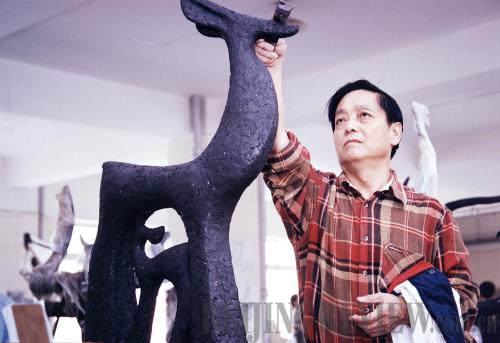 Han Meilin works on a sculpture in his studio.