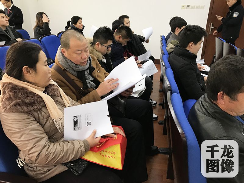 北京东城法院南区的第二法庭内，13位外来务工者领到欠薪28万元。图为外来务工人员手拿资料等待着领取欠薪。千龙网记者 查甜甜摄