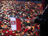 一名哀悼者手持波兰国旗在烛海前哀悼