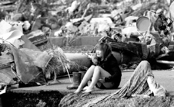 玉树地震女死尸图片;; 3月13日,日本宫城县,一名受灾女子坐在路边