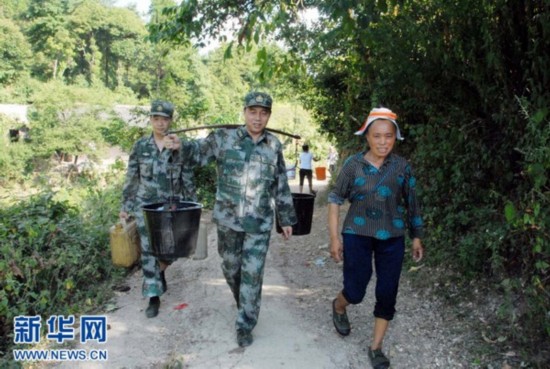 官兵们正在为严重缺水的凯里市龙场镇渔洞村苗族群众送水.