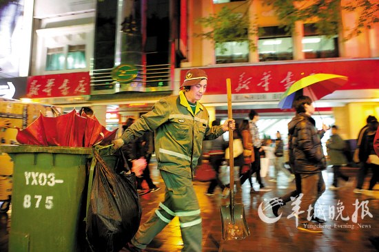 老张专门负责清理北京路步行街上的垃圾箱,下午5时开始上班,他拉着一