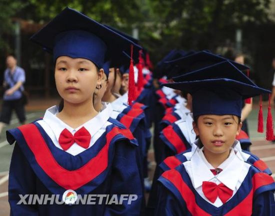 6月30日,身穿学位服的孩子们排队准备上台接受毕业证书