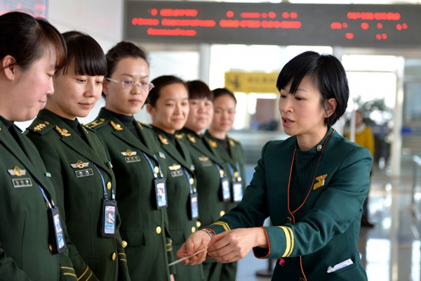 3月5日，来自台湾长荣航空公司的空姐（右）在指导呼和浩特边检站的女检查员学习礼仪知识。新华社记者任军川摄