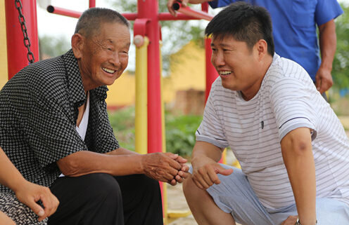 李金山(右)向年长乡亲们了解他们的精神生活情况.