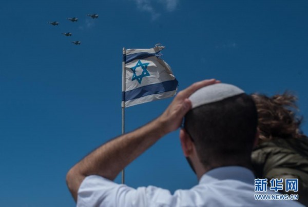 4月23日,在以色列特拉维夫的海边,一名犹太男子抱著女儿观看独立日