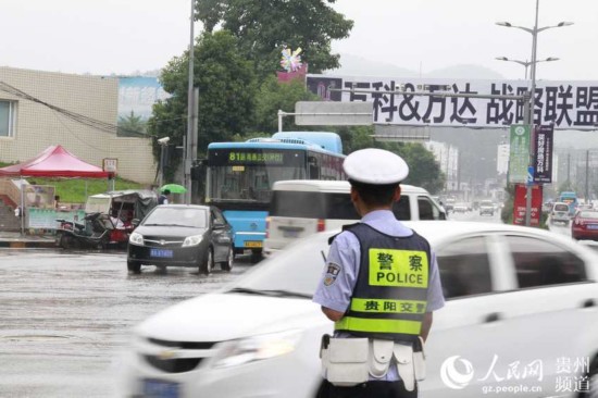 高考表情:贵阳交警大雨中执勤 爱心送考与时间