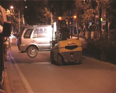 叉车把停在一家单位院中的轿车铲走，造成车辆受损。裴睿 摄