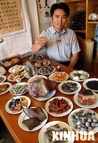 10月11日，李群生在“品尝”自己精心“烹制”的“石头宴”。 五花肉、卤猪肝、酱肘子、烧海参……满桌品种丰富、色泽鲜艳的“菜肴”令人垂涎欲滴。但这些“菜”只能看不能吃，因为全是石头。这桌“石头宴”的“烹饪大师”是34岁的郑州市民李群生，这位奇石收藏爱好者为了寻找这些石头，花费了近十年时间。