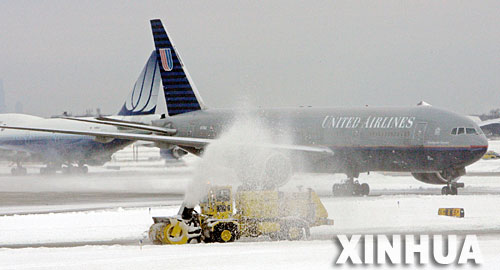 12月1日，在美国芝加哥奥黑尔国际机场，工作人员驾车在美国联合航空公司客机前清扫积雪。从11月30日起，美国中部平原地区遭到暴风雪袭击，导致美国空中交通枢纽之一的奥黑尔国际机场被迫停运，并造成至少3人死亡，约240多万户居民家中断电。 新华社发 