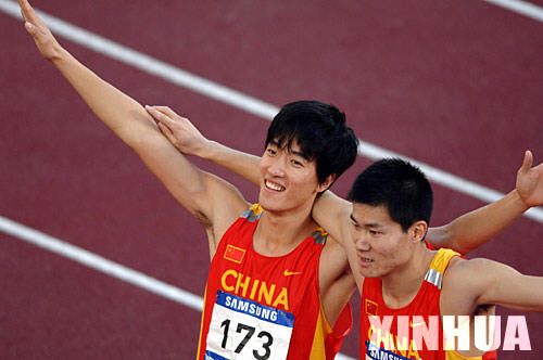 12月12日，中國選手劉翔與隊友史冬鵬（右）歡慶勝利。在多哈亞運會田徑男子110米欄決賽中，劉翔以13秒15的成績打破了亞運會紀錄並奪冠。