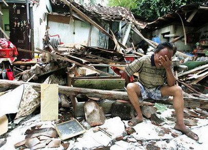 图文：印尼男子在被摧毁的家旁哭泣