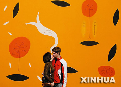 10月21日，一年一度的“博物馆之夜”艺术节在俄罗斯西伯利亚城市克拉斯诺亚尔斯克举行，来自俄罗斯、瑞士、德国和美国的艺术家展出了他们的作品。这是当天，一对情侣在俄罗斯艺术家安德烈·波兹杰耶夫创作的一幅画作前亲吻。 新华社发