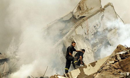 在黎巴嫩首都贝鲁特南部的郊区，消防员正在清理废墟。