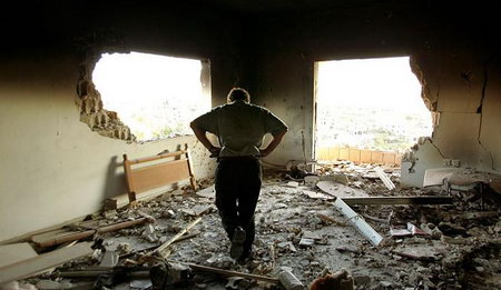 当以色列对黎巴嫩袭击之后，一名黎巴嫩男子在废墟中检查财物。