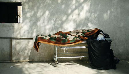 在巴格達一家醫院，一名伊拉剋婦女掀開覆蓋親友屍體毯子後哭泣。
