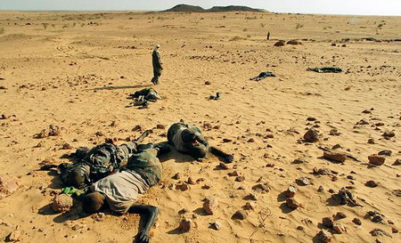 2006年10月，苏丹一名反政府武装人员从政府军的尸体旁走过。