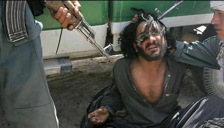 阿富汗政府軍和加拿大士兵用槍指著一名塔利班可疑人員。