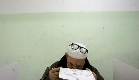 在巴勒斯坦举行大选时，一名老人正在投票站点阅读选举规则。