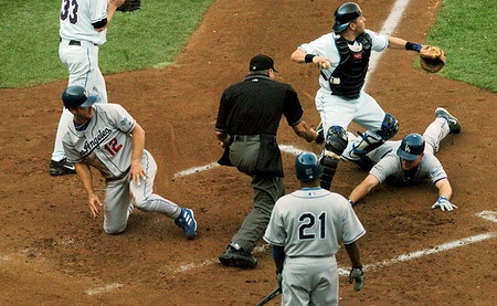 在希叶露天体育馆举行的美国职棒大联盟季后赛上，旧金山巨人队队接球手保罗-洛-杜卡在本垒触杀两名洛杉矶道奇队球员。