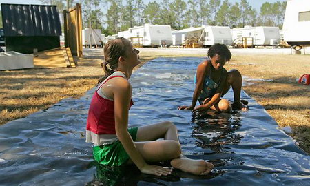 在卡特里娜飓风袭击后，美国女孩和她的女朋友做了一个简易的水滑梯。