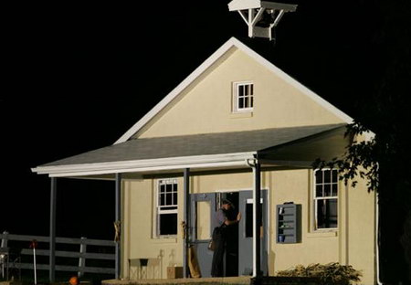 2006年10月2日,美国宾夕法尼亚发生校园枪击案件,造成5名女孩死亡。图为案发后,一名骑兵关闭血案发生地的房门。