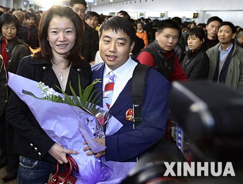 12月8日，中国乒乓球男队主教练刘国梁（前右）和妻子王瑾在机场合影。当日，中国体操队、游泳队、乒乓球队等运动队的健儿结束亚运征程回到北京。 新华社记者费茂华摄