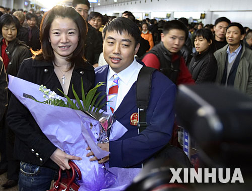 12月8日，中國乒乓球男隊主教練劉國梁（前右）和妻子王瑾在機場合影。當(dāng)日，中國體操隊、游泳隊、乒乓球隊等運動隊的健兒結(jié)束亞運征程回到北京。 新華社記者費茂華攝