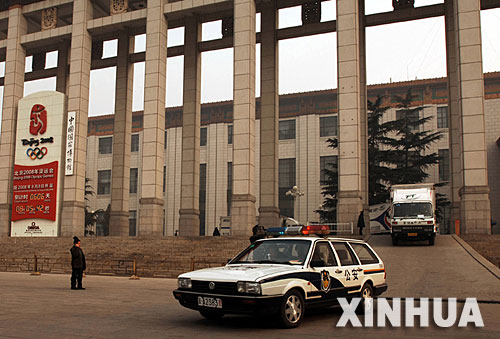 中国国家博物馆搬运文物的货车在警车的引导下出发（2006年12月11日摄）。 中国国家博物馆将于2007年4月开始扩建。日前，国家博物馆内62万件馆藏文物开始分批外迁。 新华社发（董清 摄） 