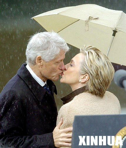 这是2004年11月18日，在美国阿肯色州的小石城，美国前总统克林顿与妻子希拉里（右）在克林顿总统图书馆开放仪式上亲吻。
