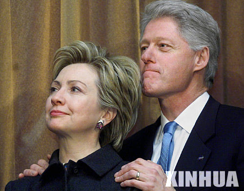 这是2001年1月3日，希拉里（左）在华盛顿宣誓就任美国国会参议员后，与丈夫克林顿一同出席招待会。