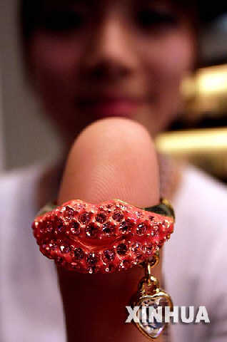 2月6日，在北京的一家首饰店内，销售人员展示“红唇香吻”情人节钻石饰品。情人节将至，北京的许多首饰商家相继推出以爱情为主题的产品来吸引消费者