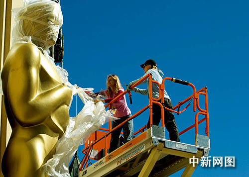 工作人员揭去保护膜 奥斯卡金人亮相好莱坞(图)