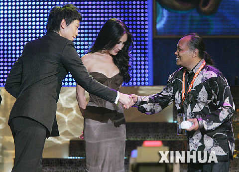  3月20日，演員鄭智熏(Rain)（左）與藝人Maggie Q向最佳原創音樂獎項的獲得者--拉夏雨·蘇朋加（右）頒獎。當日，首屆亞洲電影大獎頒獎禮在香港會展中心舉行。 新華社記者 周磊 攝 