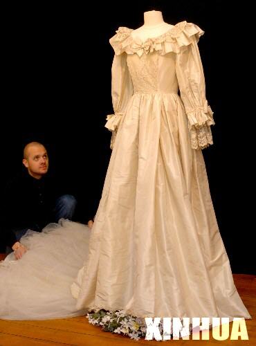 2005年11月29日，在英国伦敦一家拍卖行，一名工作人员展示即将被拍卖的戴安娜王妃的婚纱复制品。在1981年7月29日查尔斯王子与戴安娜王妃的盛大婚礼上，戴妃曾穿着一件裙摆达8米长的象牙色拖地长裙,惊艳四座。这次将被拍卖的复制品是由原设计者依原样复制,预计拍卖价将超过5万镑。